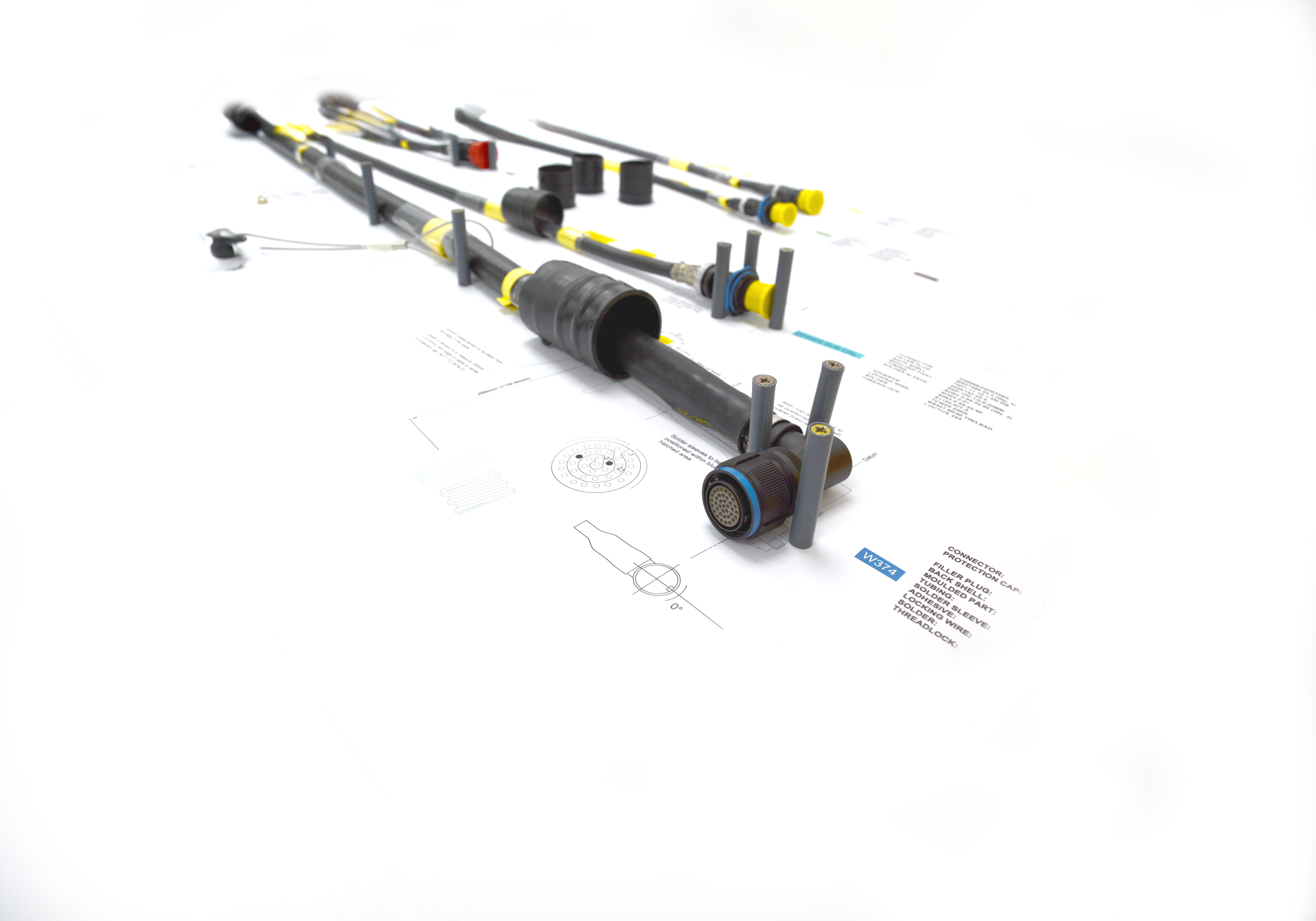 Full cable harness assembly laid out over annotated technical drawings, showing multiple connectors and branched breakouts